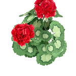 Top view of a red paper geranium centerpiece with bright layered blooms and decorative green patterned paper leaves.