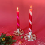 lighted 2 Red Pink Taper Candles in a holder with red background