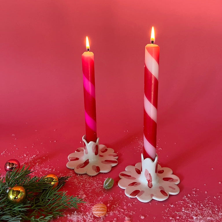 lighted 2 Red Pink Taper Candles in a holder with red background