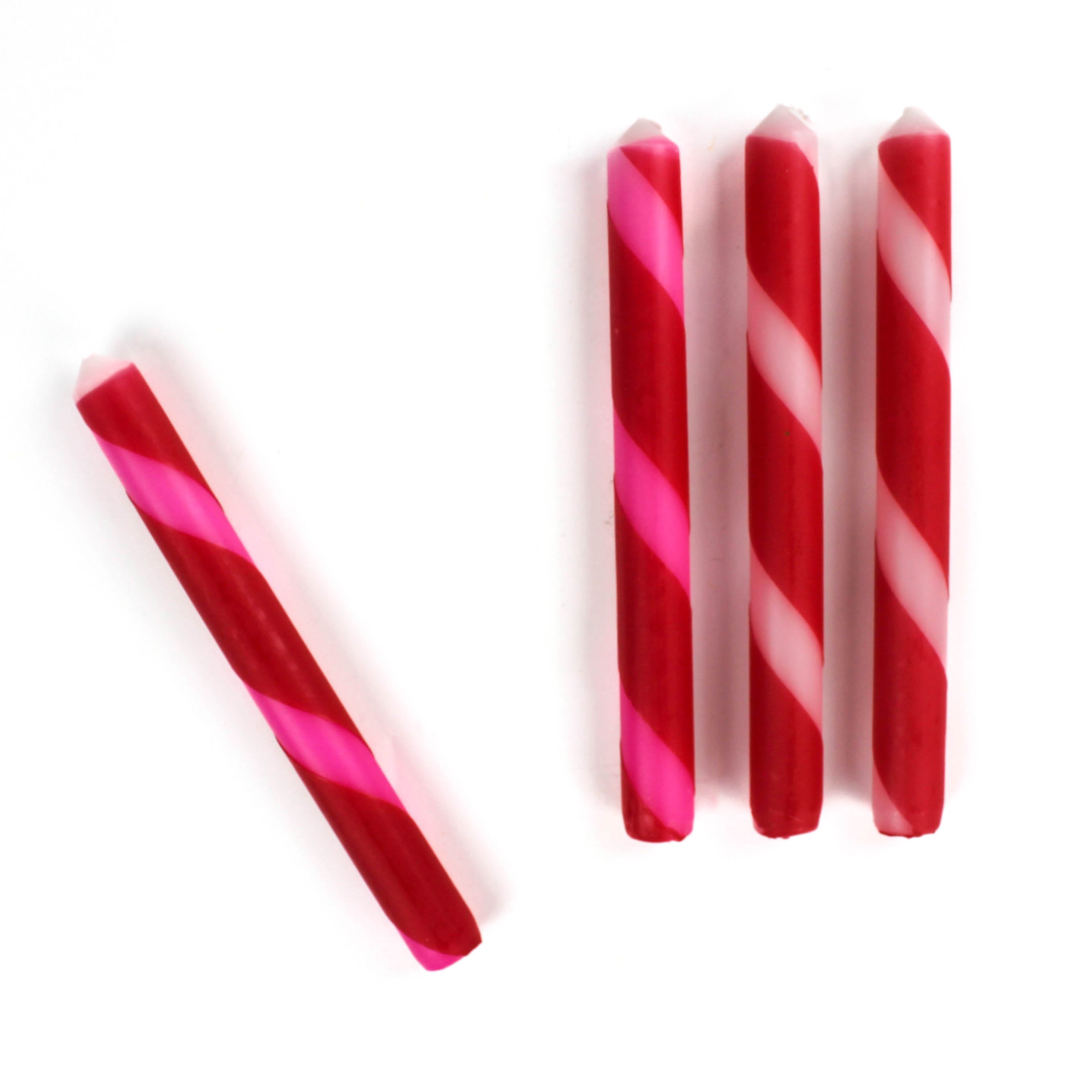 4 Red Pink Taper Candles laying on a white background