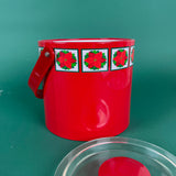 Red holiday ice bucket  open with poinsettia design band and handle on a green background