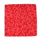 Red napkin cloth with playful pink squiggle pattern on a white background, modern kitchen linen perfect for Christmas tea towel styling, holiday cooking, and seasonal home décor