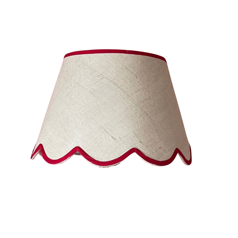 a scalloped lampshade with red trim