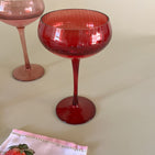 a red colored coupe glass