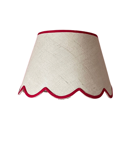 a scalloped lampshade with red trim