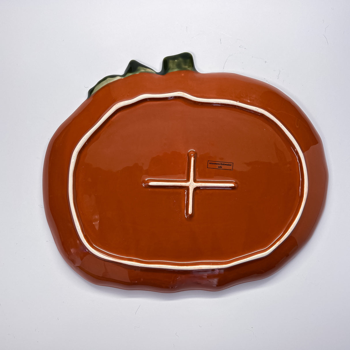 the reverse side of a ceramic pumpkin serving platter