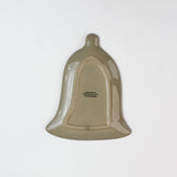 reverse side of a bell shaped christmas accent plate on a white background