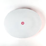 bottom view of the Hand-Painted Metal Christmas Santa Tray featuring a cheerful Santa Claus face with a red hat on a pink circular background with scalloped edges.