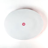 bottom view of the Hand-Painted Metal Christmas Santa Tray featuring a cheerful Santa Claus face with a red hat on a pink circular background with scalloped edges.