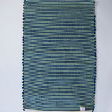 reverse side of A madcap cottage navy  accent rug with a lattice motif across the front