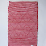 the reverse side of A madcap cottage yellow and green striped accent rug with a lattice motif across the front