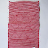 the reverse side of A madcap cottage yellow and green striped accent rug with a lattice motif across the front