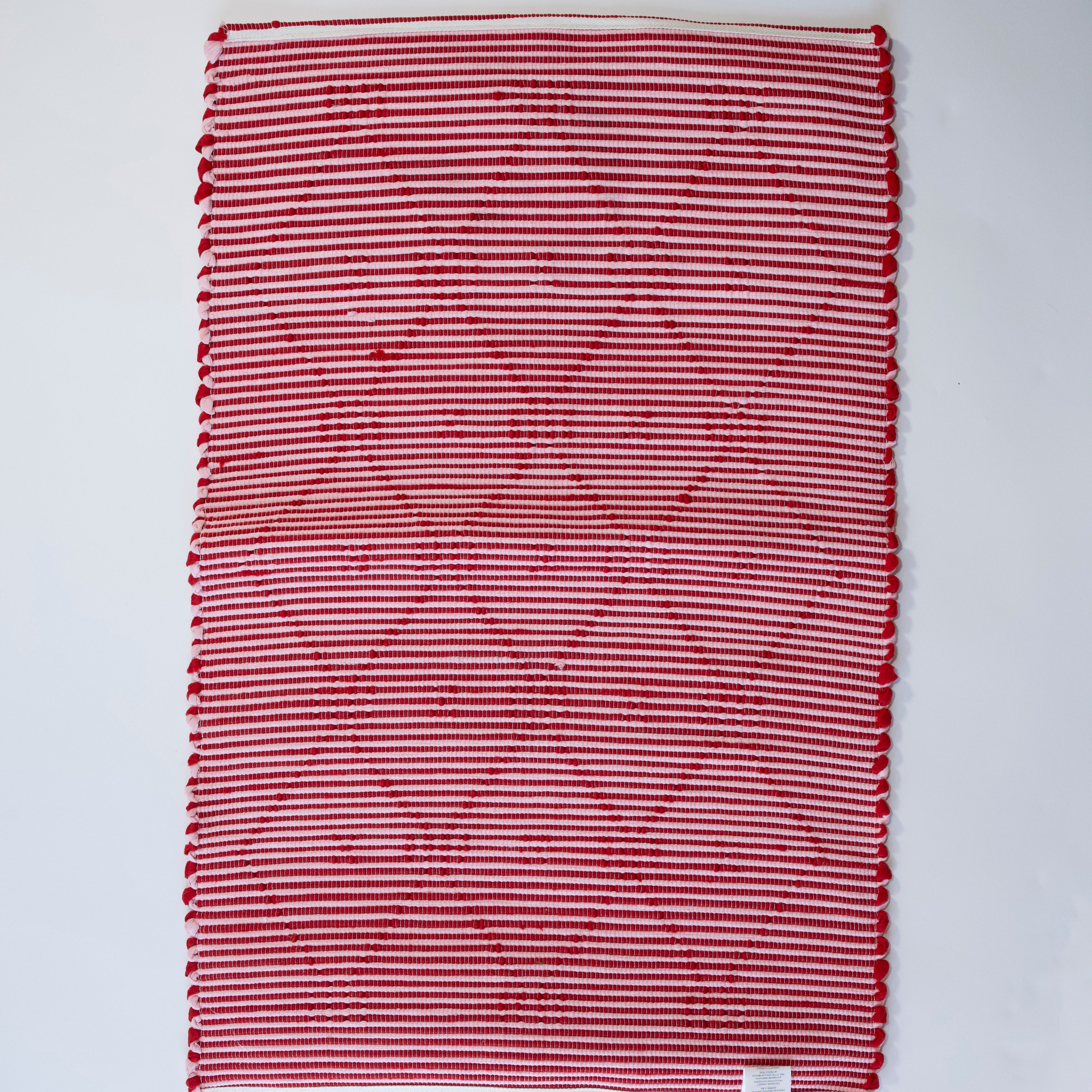 the reverse side of A madcap cottage yellow and green striped accent rug with a lattice motif across the front