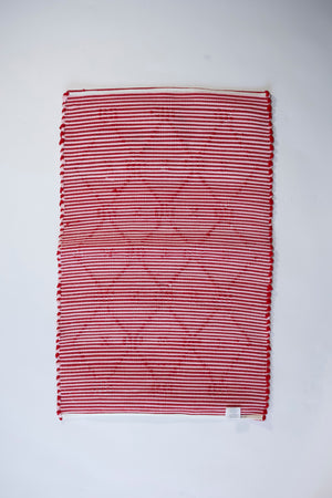 the reverse side of A madcap cottage yellow and green striped accent rug with a lattice motif across the front