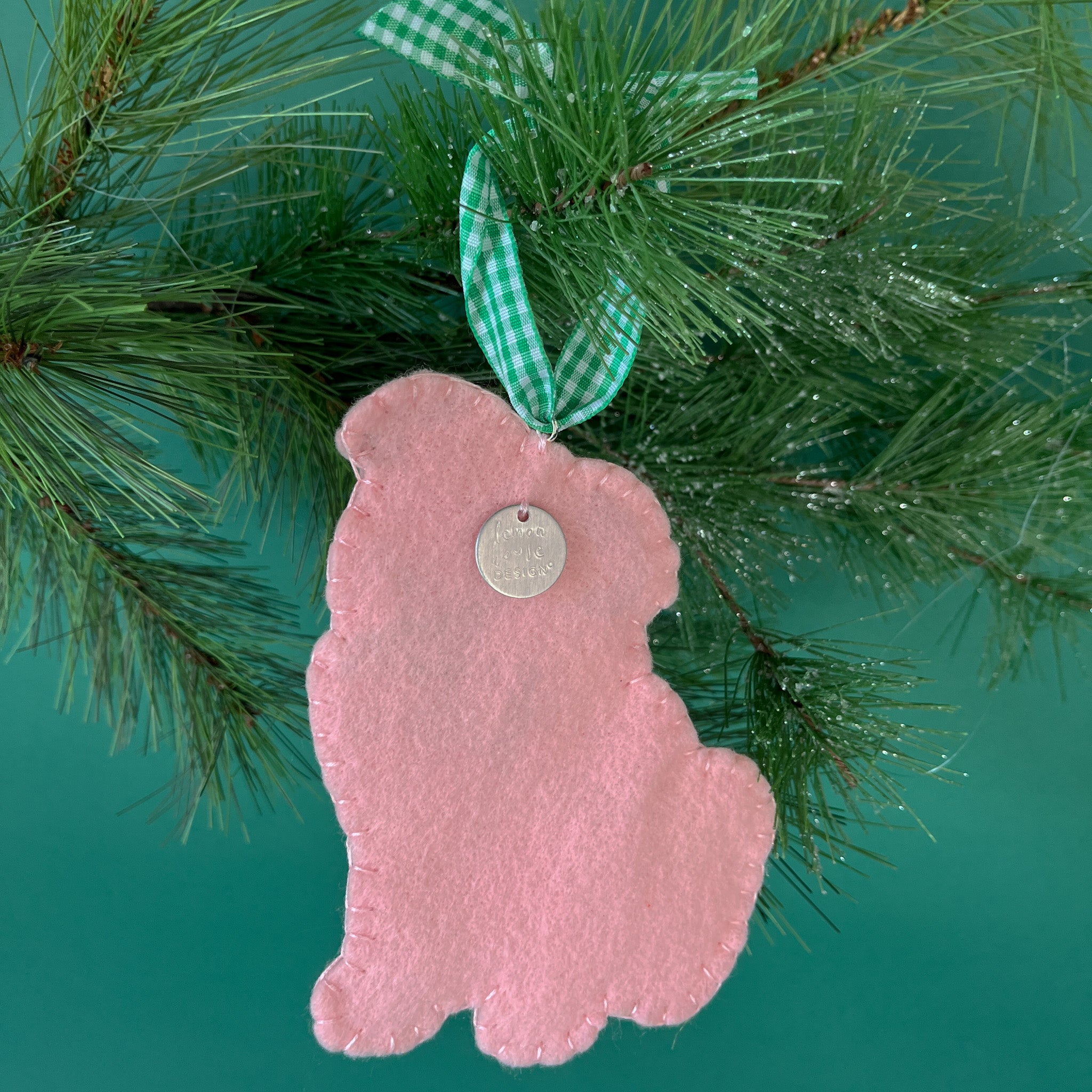 back of a felt Christmas ornament featuring a cute pug with a bright green bow tie and green gingham ribbon
