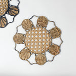 Decorative woven rattan placemat with shell patterns on a white background