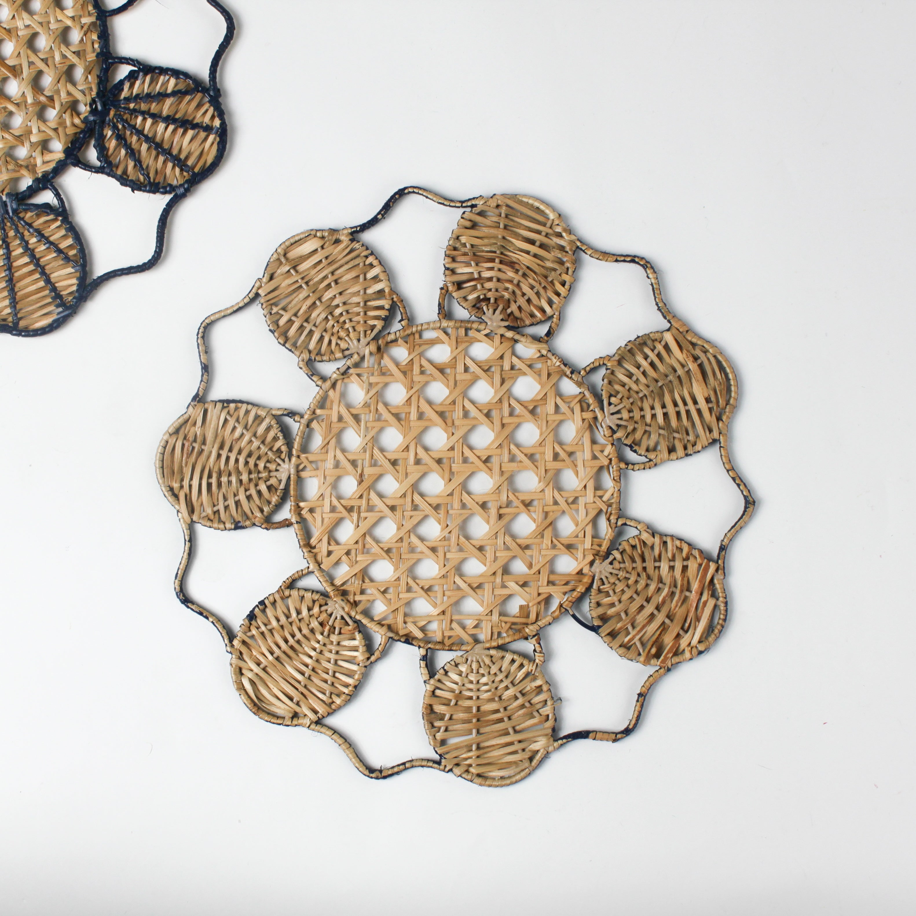 Decorative woven rattan placemat with shell patterns on a white background