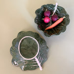 two ceramic cabbage leaf bowls one filled with radishes the other showing the reverse side
