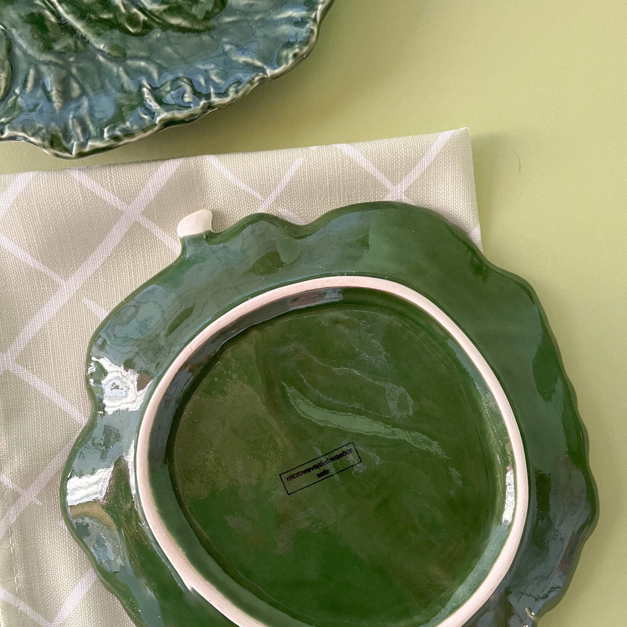 reverse side of a green ceramic cabbage leaf plate
