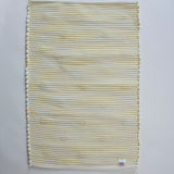 reverse side of a rectangular yellow accent rug with small daisy shaped accents scattered across it. 