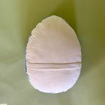 reverse side of a purple easter egg pillow with text that reads "Happy Easter"