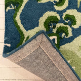 the reverse side of a blue and green rug with chinoiserie boatmen and pagoda motifs from madcap cottage.
