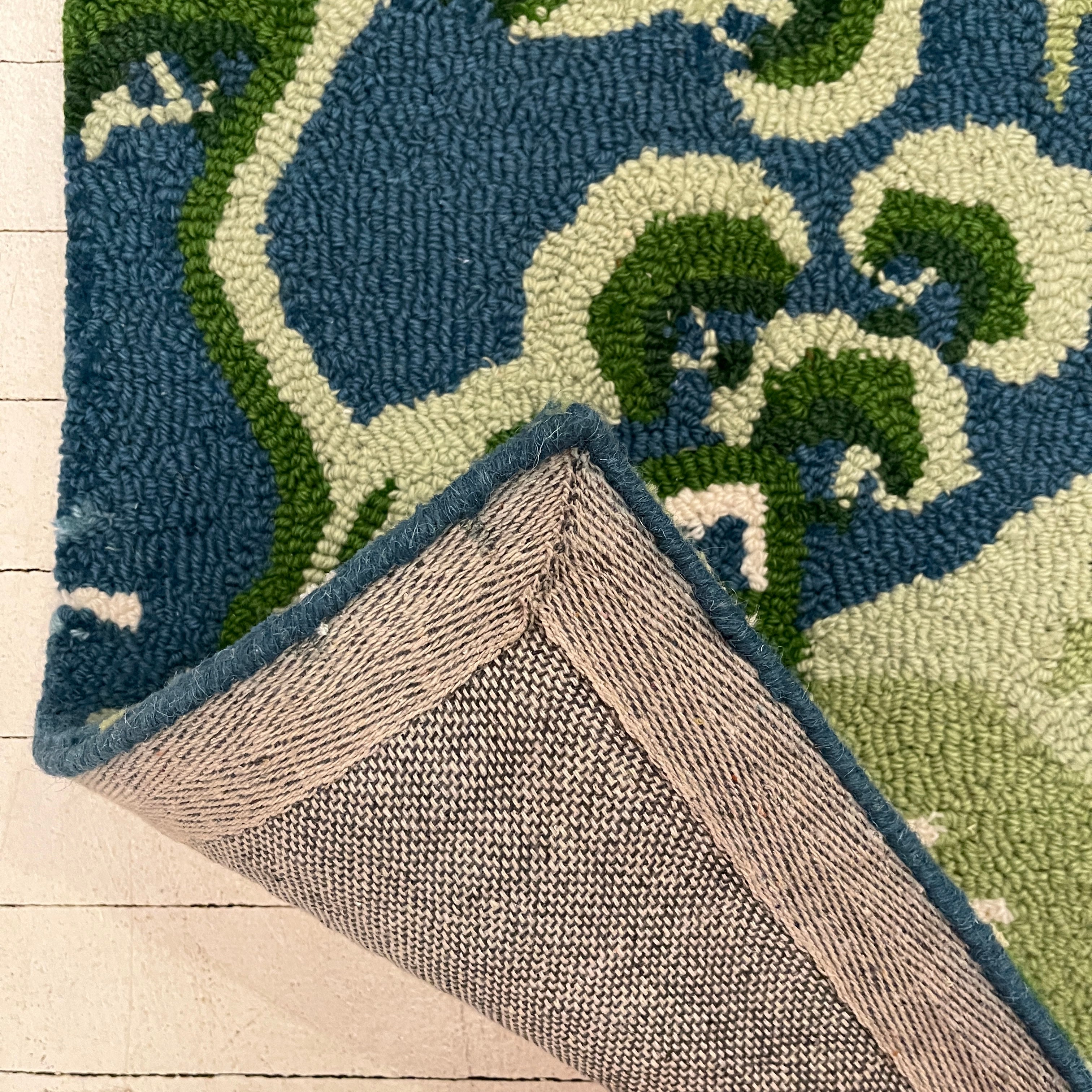 the reverse side of a blue and green rug with chinoiserie boatmen and pagoda motifs from madcap cottage.