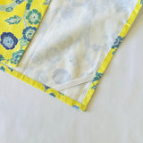 the reverse of a yellow chinoiserie tea towel with blue cherry blossom motifs.