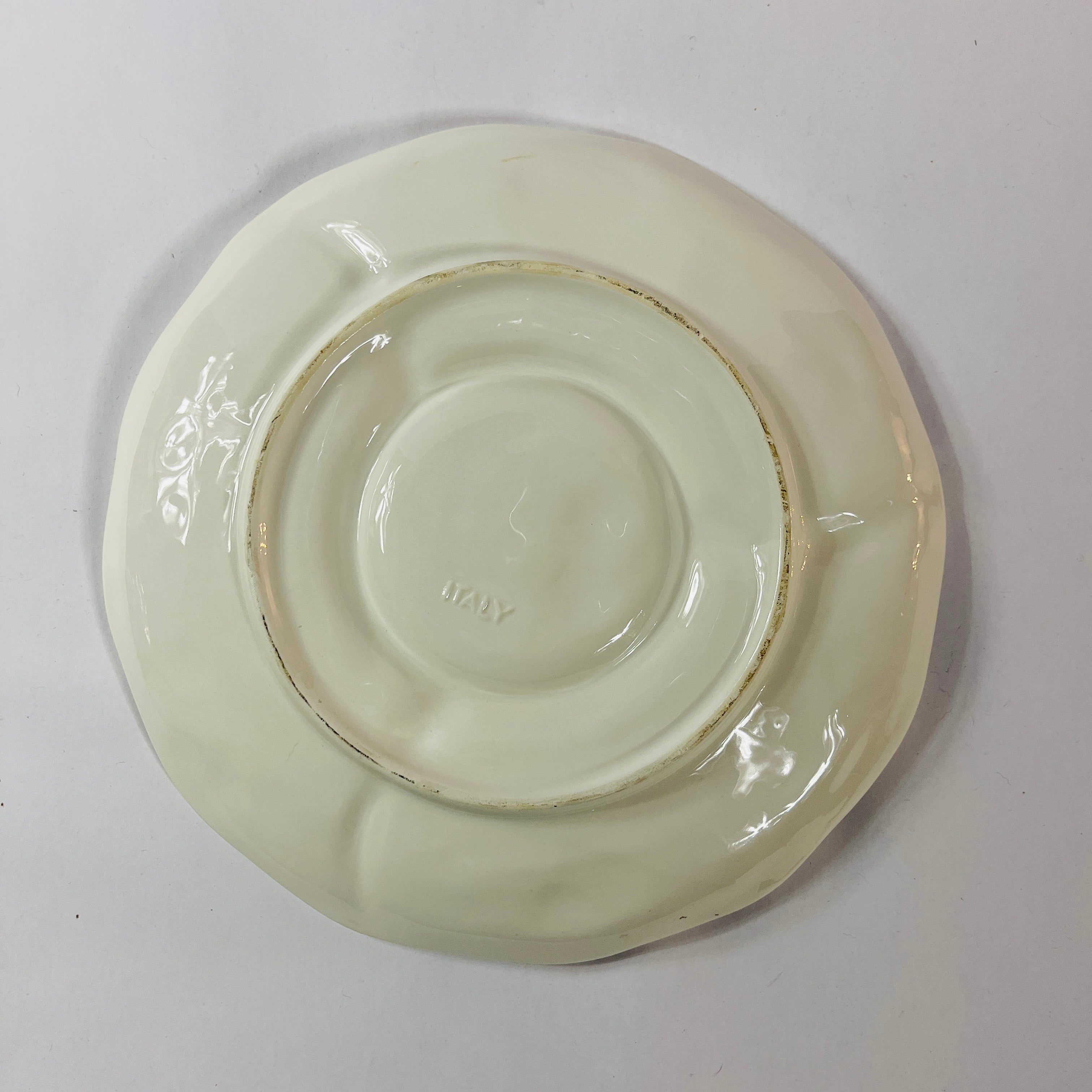 reverse side of a white vintage strawberry pitcher with strawberry motifs decorating the side