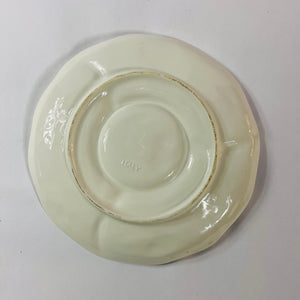 reverse side of a white vintage strawberry pitcher with strawberry motifs decorating the side