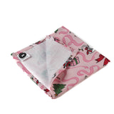 a folded Nutcracker pink christmas napkin featuring motifs of ballerinas, ribbons, christmas trees and nutcrackers on a white background. 