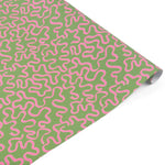Playful gift wrap featuring whimsical pink ribbon patterns on a vibrant green background for gifting.