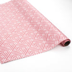 a roll of wrapping paper with a geometric lattice pattern in pink