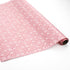 a roll of wrapping paper with a geometric lattice pattern in pink