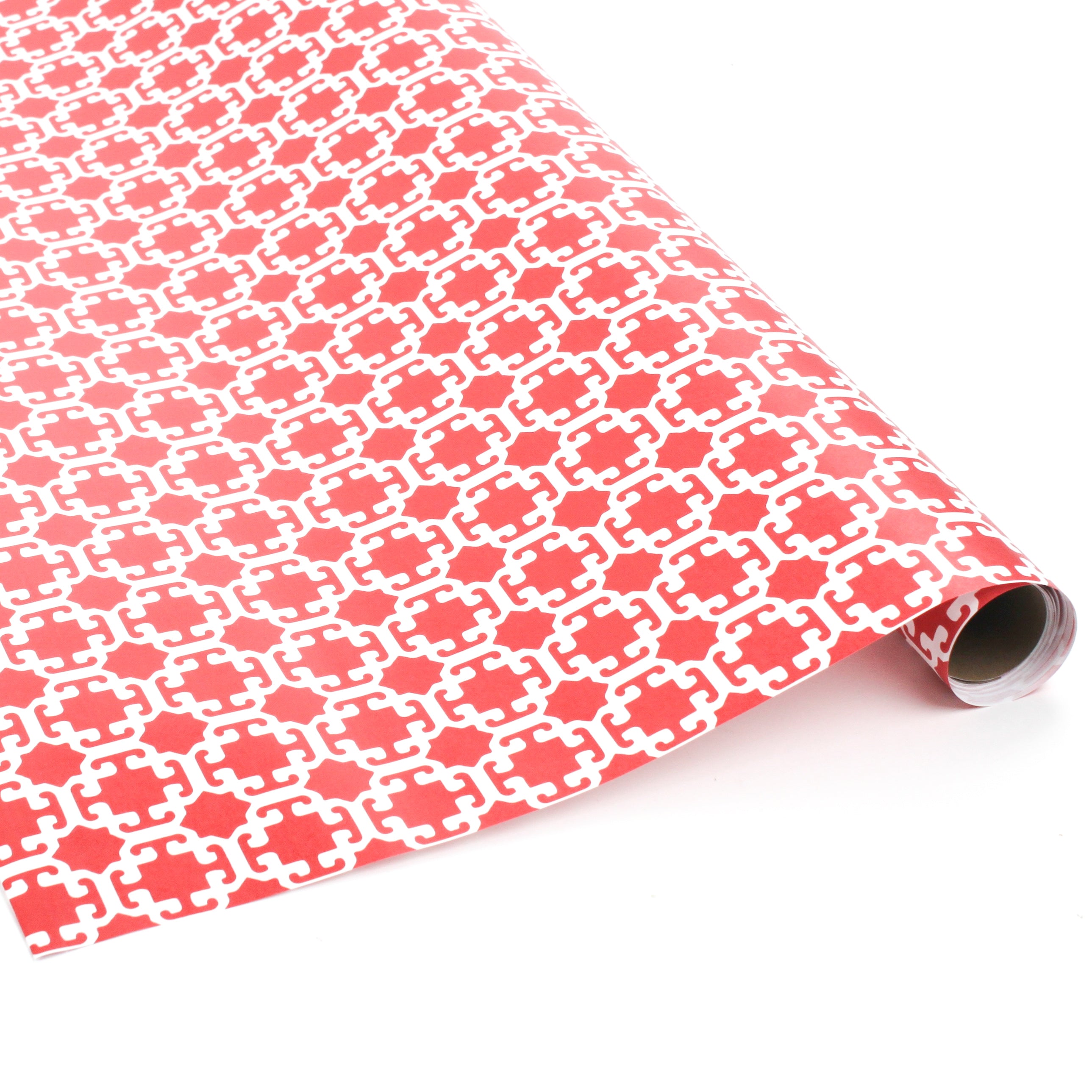 Roll of red wrapping paper with white geometric Monserrat pattern.