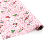 Roll of pink nutcracker Christmas wrapping paper featuring playful holiday characters and pink ribbon accents.