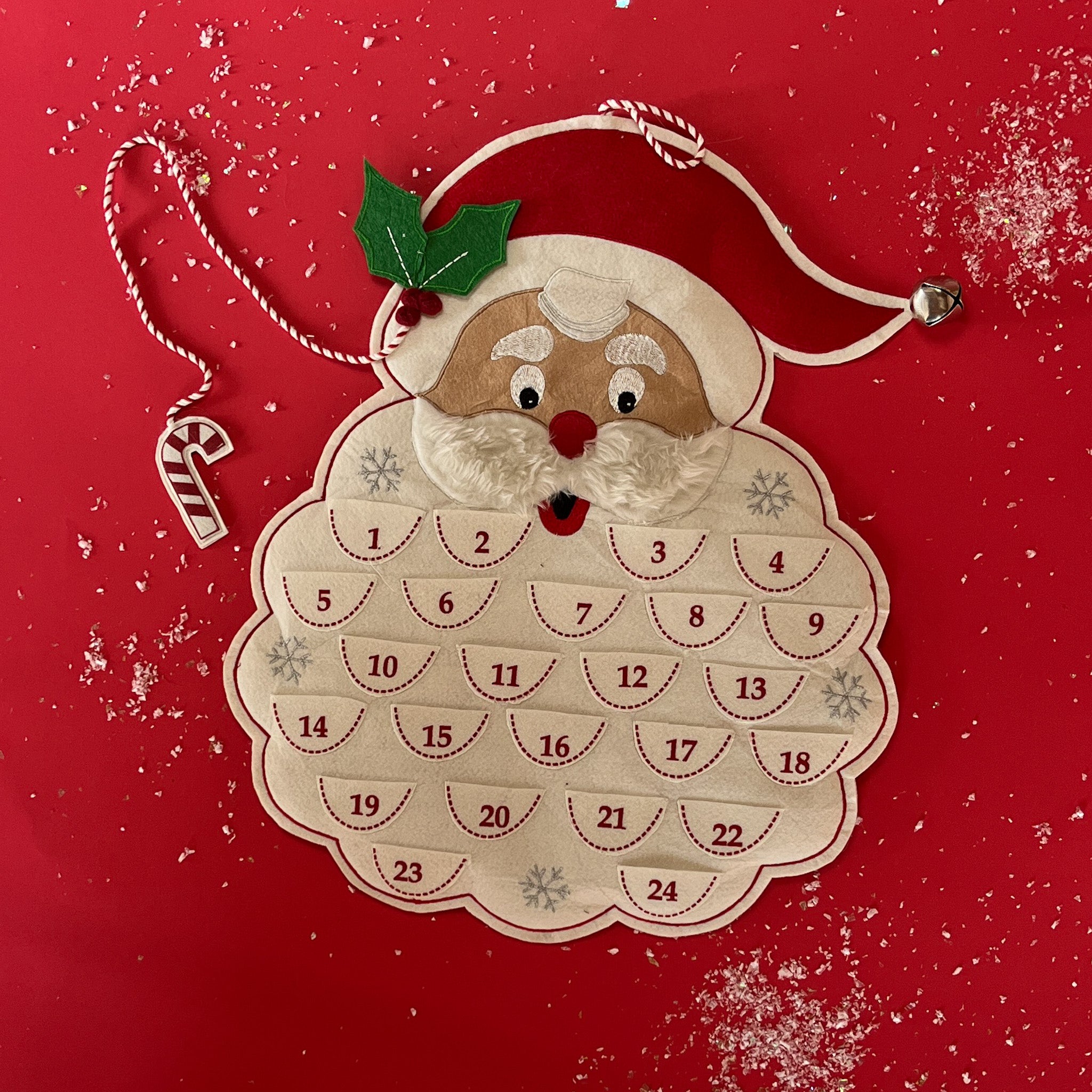A santa shaped felt advent calendar against a red background. 