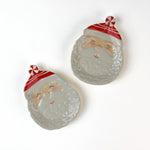 Two ceramic Santa Claus face christmas plates on a white background