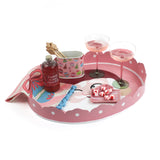 Pink christmas tray with a santa face on the bottom filled with candy and drinks on a white background