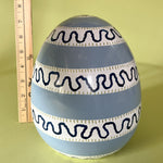 a blue striped large decorative easter eggs with a ruler behind to illustrate scale