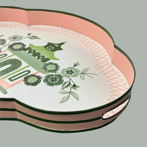 A pink and green metal tray featuring a central pagoda motif surrounded by blossoms. 