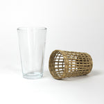 seagrass wrapped glasses from madcap cottage with the seagrass wrapping on the side to the right of a plain glass. 