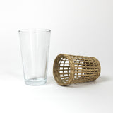 seagrass wrapped glasses from madcap cottage with the seagrass wrapping on the side to the right of a plain glass. 