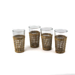 Set of four clear drinking glasses with woven rattan sleeves.