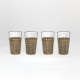 Four glasses with wicker sleeves on a white background