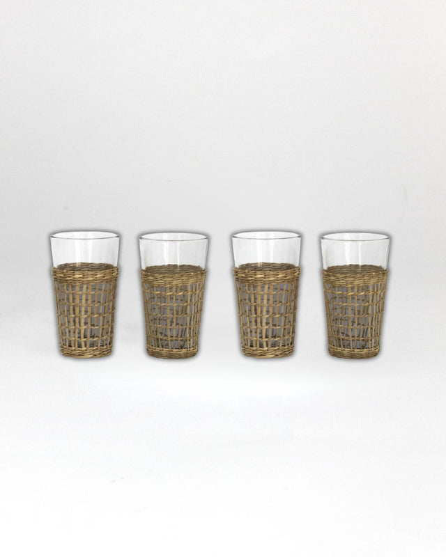 Four glasses with wicker sleeves on a white background