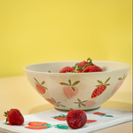 A large strawberry serving bowl with white and pink strawberry motifs decorating the exterior