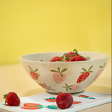 A large strawberry serving bowl with white and pink strawberry motifs decorating the exterior