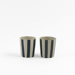 2 blue striped ceramic cups in on a white background. 