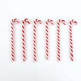 a set of 6 red and white candy cane drinks stirrers against a plain white background. 